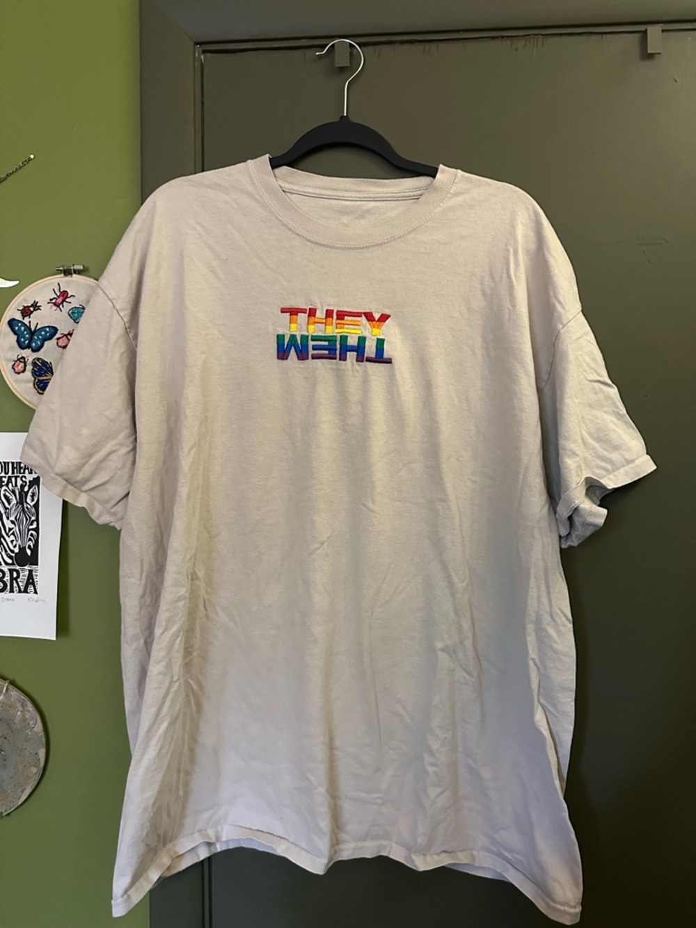 Tan THEY/THEM shirt with rainbow letters